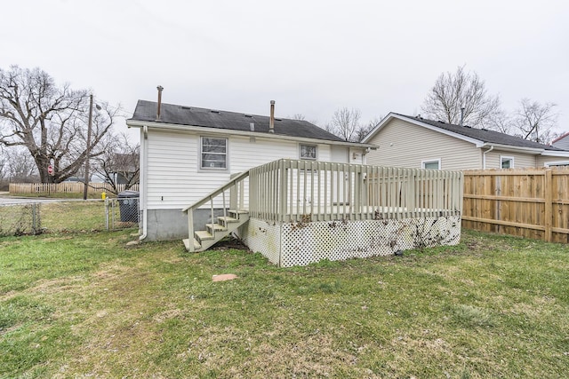 rear view of property featuring a yard and a deck