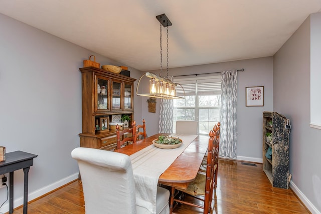 dining space with wood-type flooring