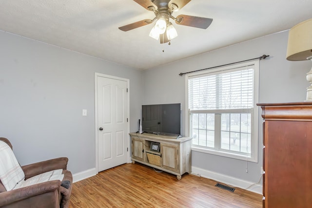 living area featuring light hardwood / wood-style flooring and ceiling fan