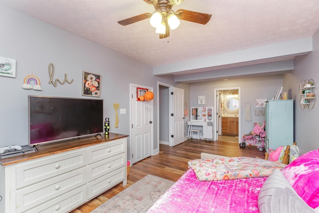 bedroom with beamed ceiling, dark hardwood / wood-style floors, a textured ceiling, and ensuite bathroom