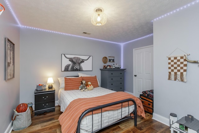 bedroom featuring dark hardwood / wood-style floors and a textured ceiling