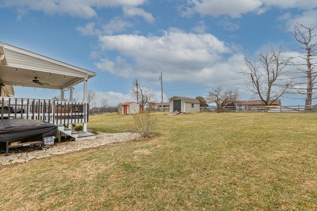 view of yard with ceiling fan and a storage unit