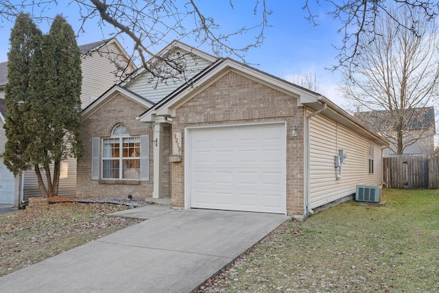 view of front of home with a garage, central AC unit, and a front yard