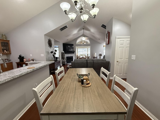 403 Chateau Pl, Bronston, KY 42518 - dining space featuring dark hardwood / wood-style flooring, a fireplace, ceiling fan with notable chandelier, and vaulted ceiling