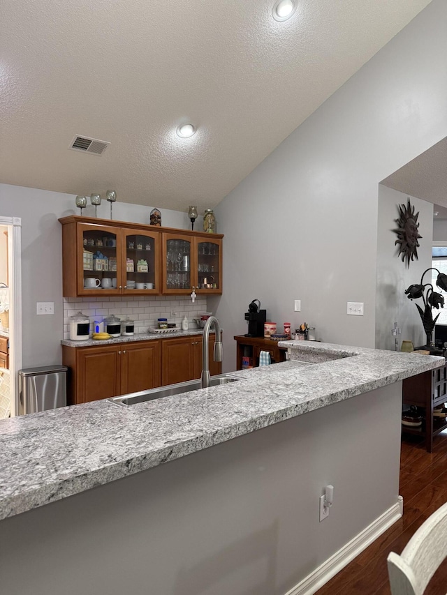 403 Chateau Pl, Bronston, KY 42518 - bar featuring lofted ceiling, sink, dark wood-type flooring, and light stone countertops
