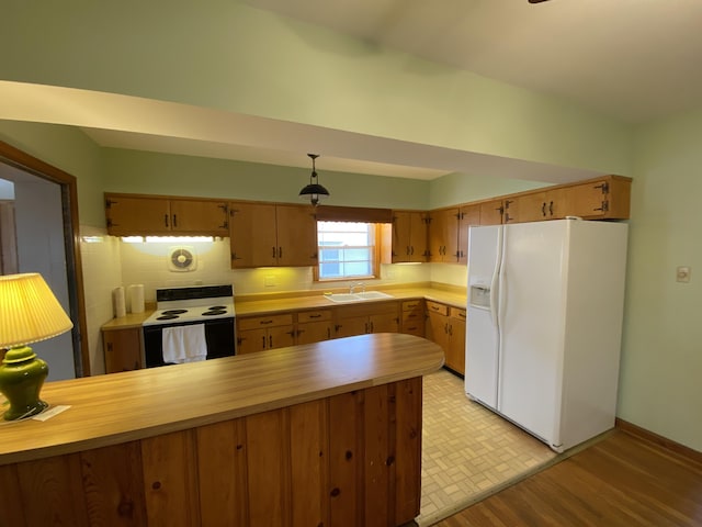 kitchen featuring sink, light hardwood / wood-style flooring, electric range, white fridge with ice dispenser, and kitchen peninsula