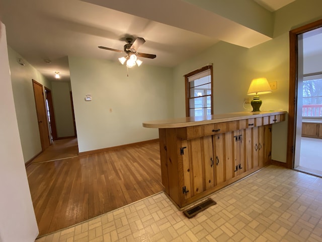 kitchen with light hardwood / wood-style flooring, a wealth of natural light, ceiling fan, and kitchen peninsula