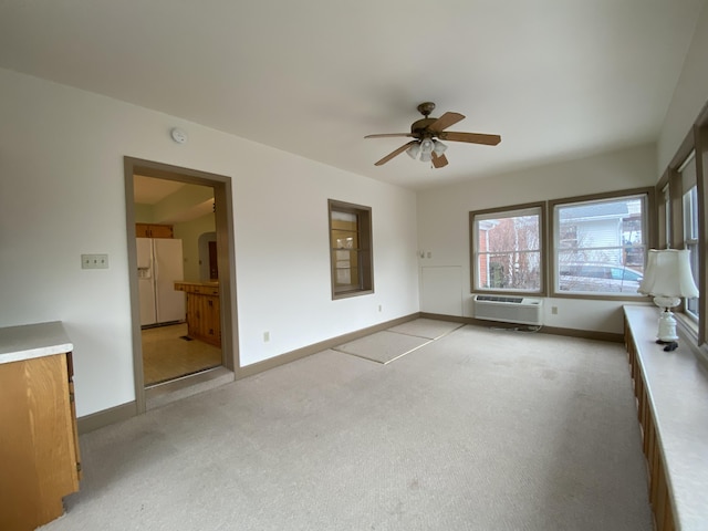 spare room with light carpet, a wall mounted air conditioner, and ceiling fan