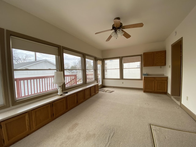 unfurnished sunroom with ceiling fan