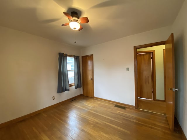 unfurnished bedroom with ceiling fan and wood-type flooring