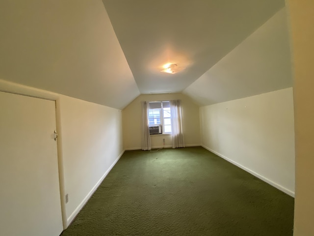 additional living space featuring lofted ceiling, cooling unit, and dark carpet