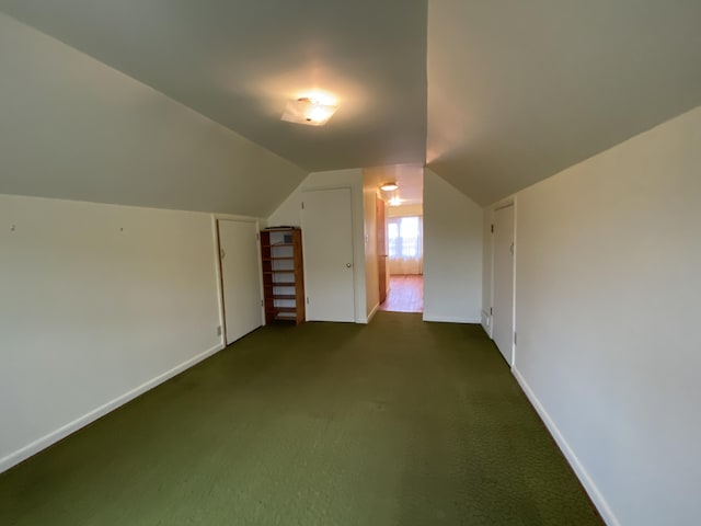 bonus room featuring dark carpet and vaulted ceiling