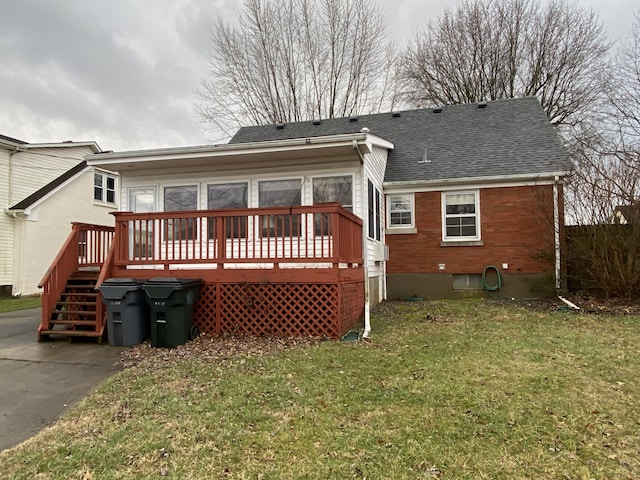 rear view of property with a yard and a deck