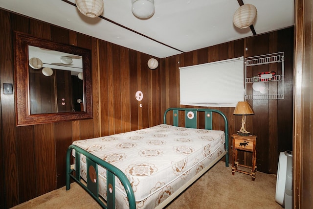 bedroom featuring light carpet and wood walls