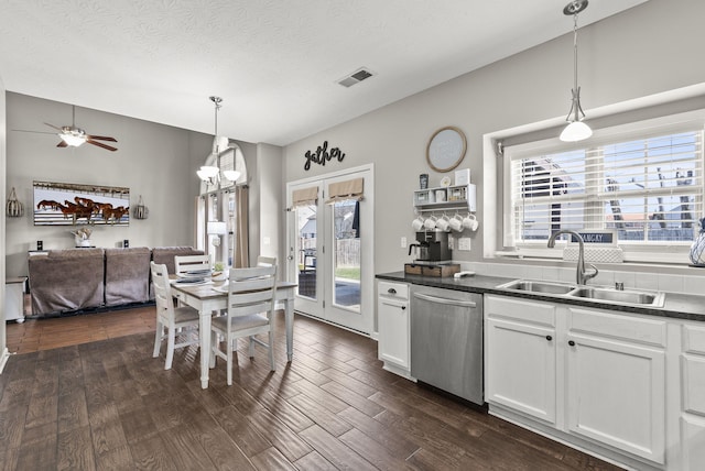 kitchen with dark hardwood / wood-style floors, pendant lighting, sink, white cabinets, and stainless steel dishwasher