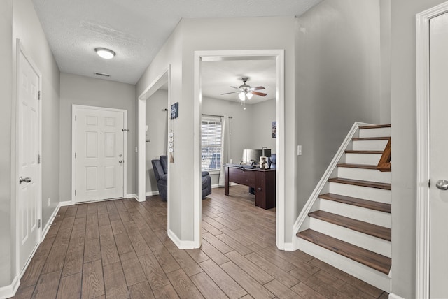 entryway featuring hardwood / wood-style flooring, ceiling fan, and a textured ceiling