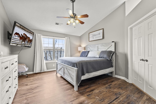 bedroom featuring dark wood-type flooring, ceiling fan, vaulted ceiling, and a closet