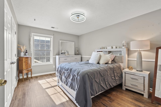 bedroom featuring dark hardwood / wood-style floors and a textured ceiling