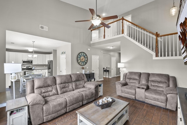 living room with a high ceiling, dark hardwood / wood-style floors, and ceiling fan