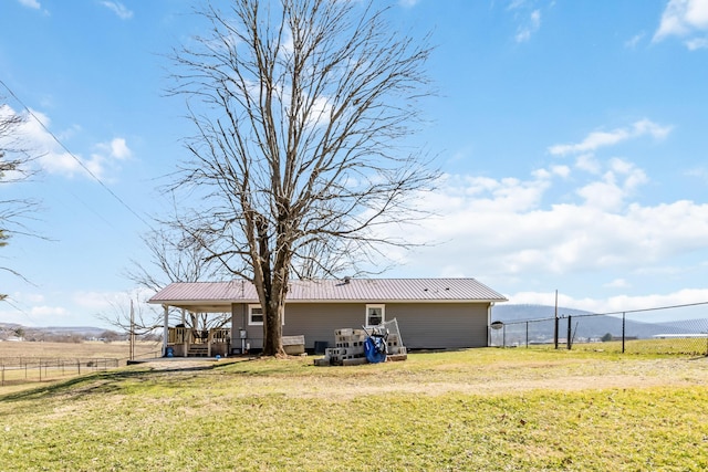 back of house featuring a yard and a rural view