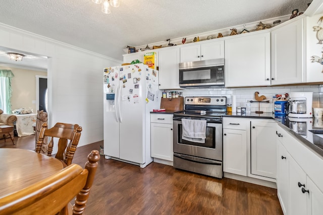 kitchen with white cabinetry, tasteful backsplash, crown molding, appliances with stainless steel finishes, and dark hardwood / wood-style floors