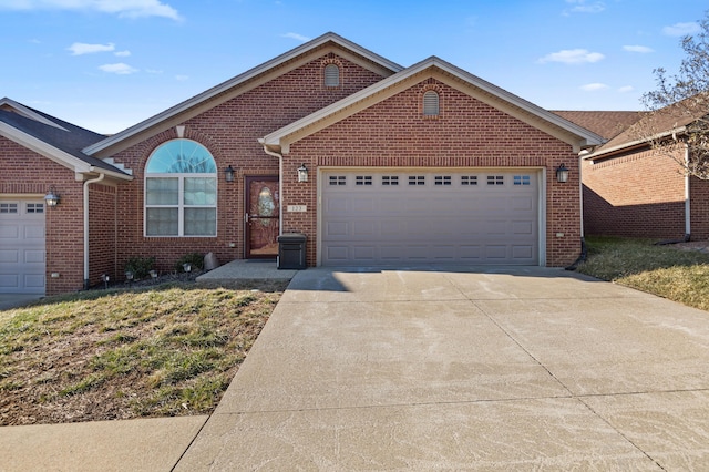 single story home with concrete driveway, brick siding, and an attached garage