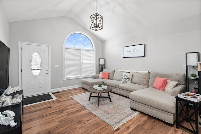 living room featuring lofted ceiling, dark hardwood / wood-style flooring, and a notable chandelier