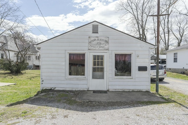 view of front of home with a front lawn and an outdoor structure