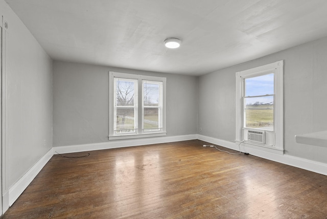 unfurnished room featuring cooling unit, dark hardwood / wood-style flooring, and a wealth of natural light