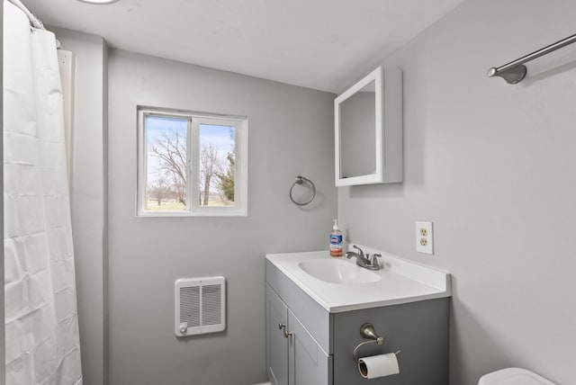 bathroom featuring vanity, toilet, and heating unit