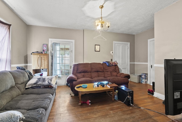 living room with an inviting chandelier, wood-type flooring, and a textured ceiling