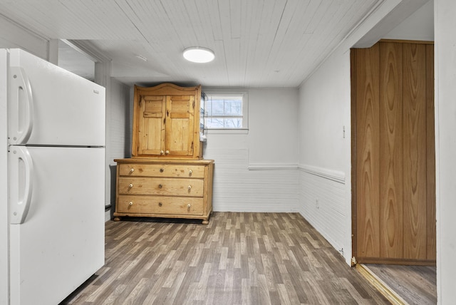 kitchen featuring white refrigerator, wood-type flooring, and wood ceiling