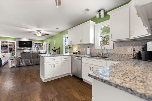 kitchen with sink, white cabinets, stainless steel dishwasher, light stone counters, and kitchen peninsula