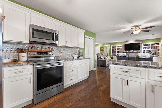 kitchen with dark hardwood / wood-style floors, white cabinets, dark stone counters, decorative backsplash, and stainless steel appliances