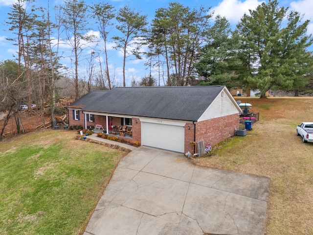 single story home featuring a porch, a garage, and a front yard