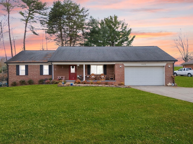 single story home featuring a garage, covered porch, and a lawn