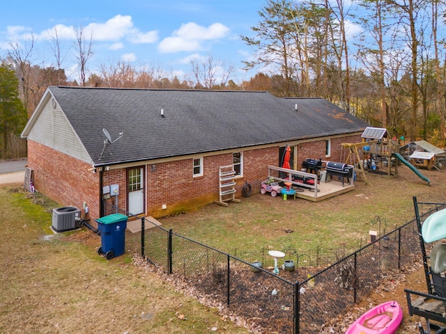 back of property featuring a playground, a yard, and cooling unit