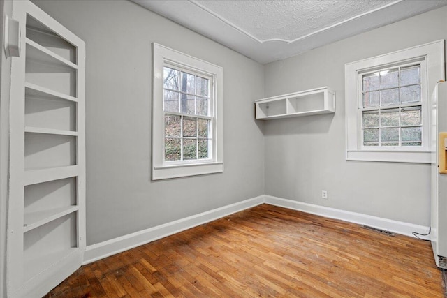 empty room featuring hardwood / wood-style flooring and a textured ceiling