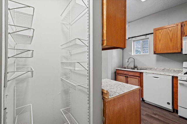 kitchen featuring sink, white appliances, and dark wood-type flooring