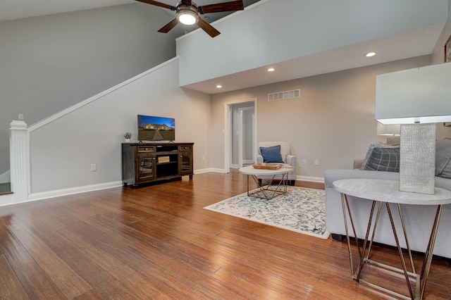 living room with hardwood / wood-style flooring, ceiling fan, and high vaulted ceiling