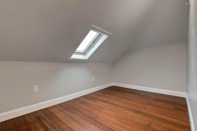 bonus room with lofted ceiling with skylight and hardwood / wood-style floors