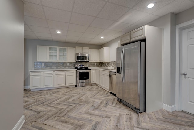 kitchen with decorative backsplash, stainless steel appliances, and white cabinets