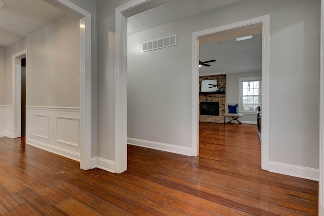 hall with hardwood / wood-style floors and a textured ceiling