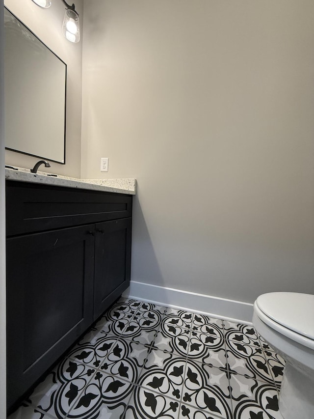 bathroom featuring tile patterned flooring, vanity, and toilet