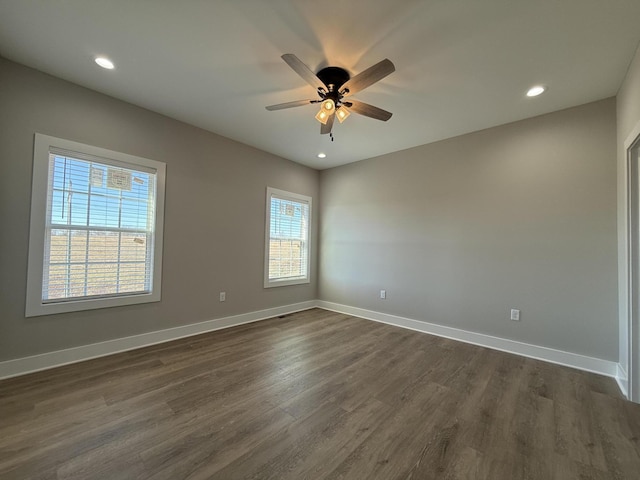 spare room with dark hardwood / wood-style flooring and ceiling fan