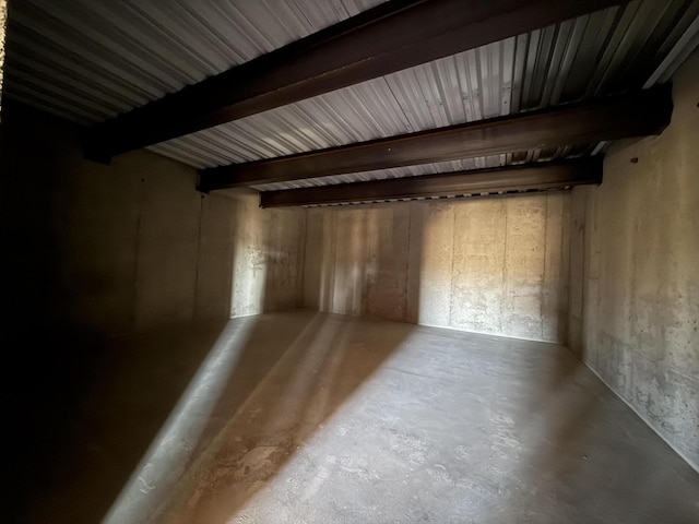 interior space featuring beam ceiling and concrete floors