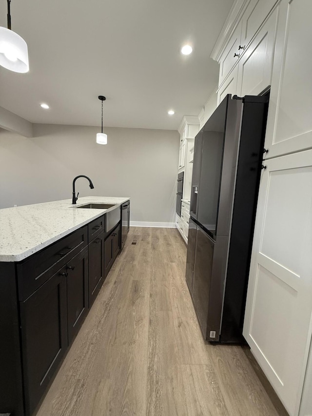 kitchen with sink, white cabinetry, decorative light fixtures, light hardwood / wood-style flooring, and black appliances