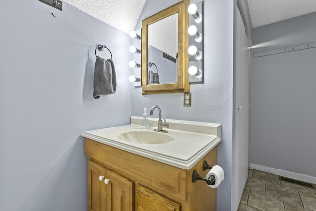 bathroom with vanity, tile patterned floors, and a textured ceiling