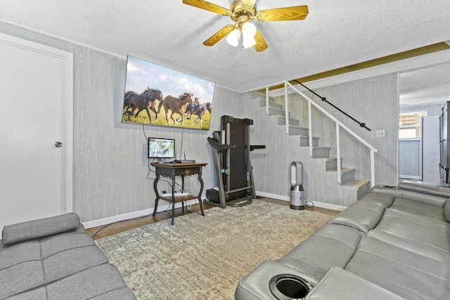 living room featuring ceiling fan, hardwood / wood-style floors, and a textured ceiling