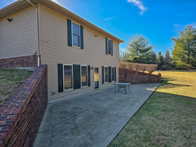 rear view of house with a patio and a lawn